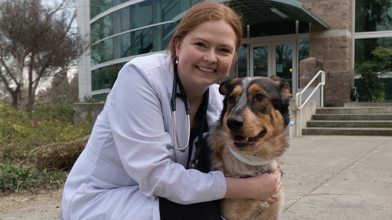 Veterinarian and dog in front of a buiding